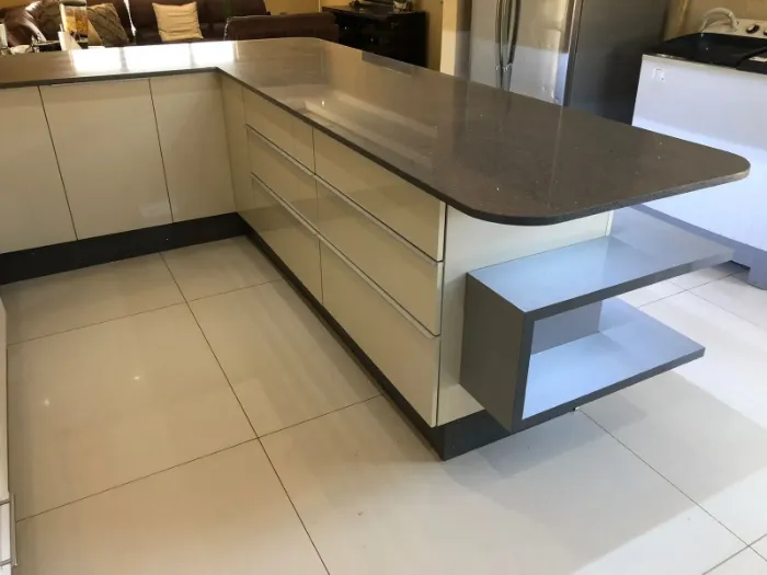 LED-lit kitchen cabinetry with two built-in shelving spaces.
